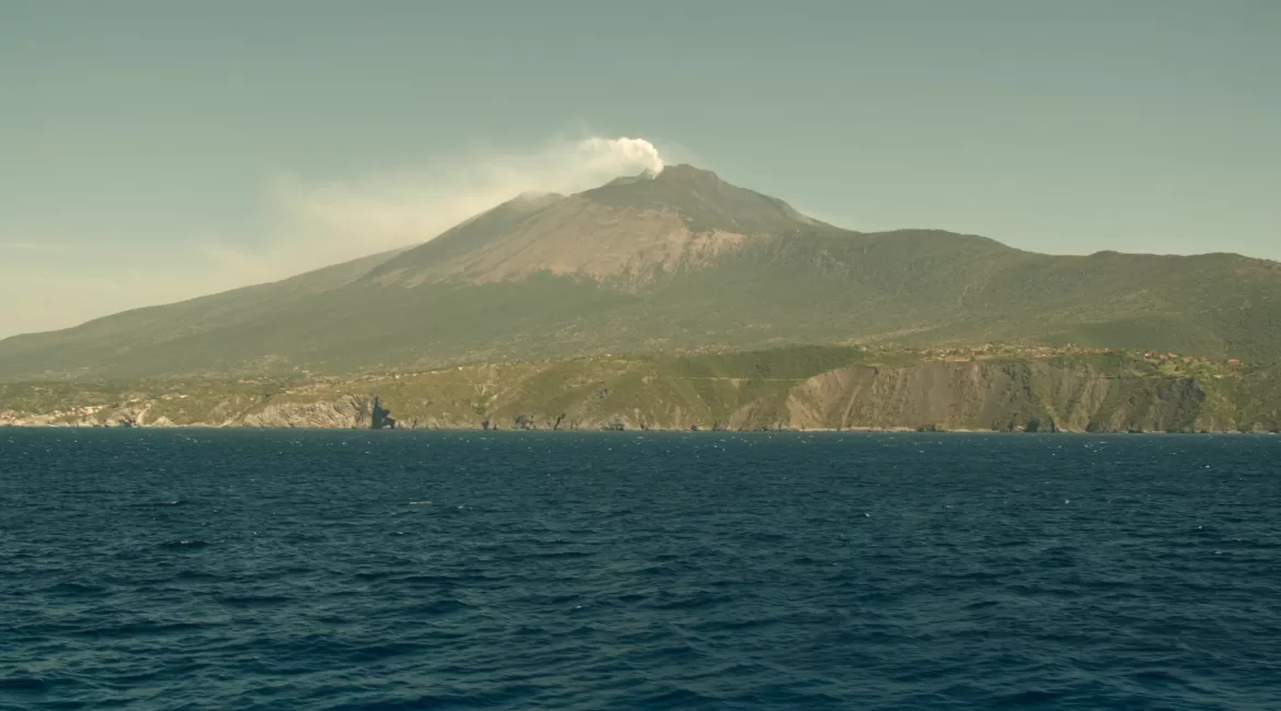 Mount Etna seen from the sea off the Sicilian coast with a vapour plume above the summit