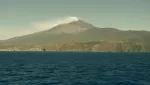 Mount Etna seen from the sea off the Sicilian coast with a vapour plume above the summit