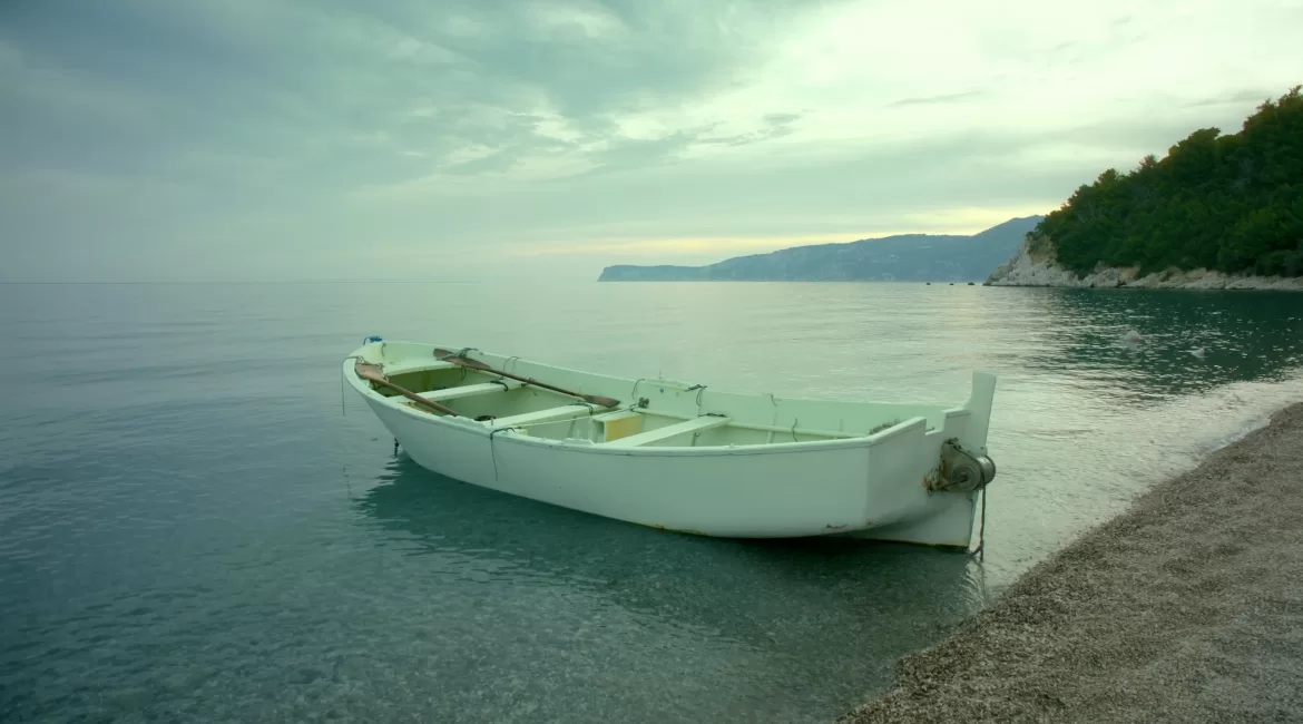 How to book a boat tour in Taormina: a small boat moored at the shore