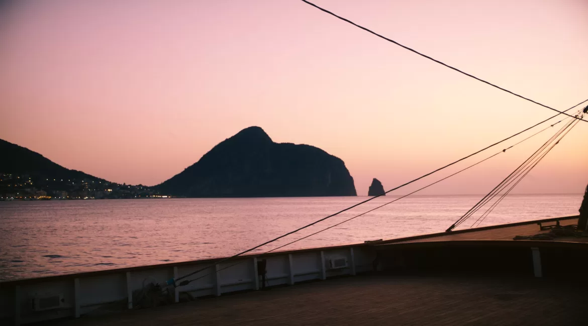 An aperitivo on the water in Taormina: a boat deck at sunset off the coast