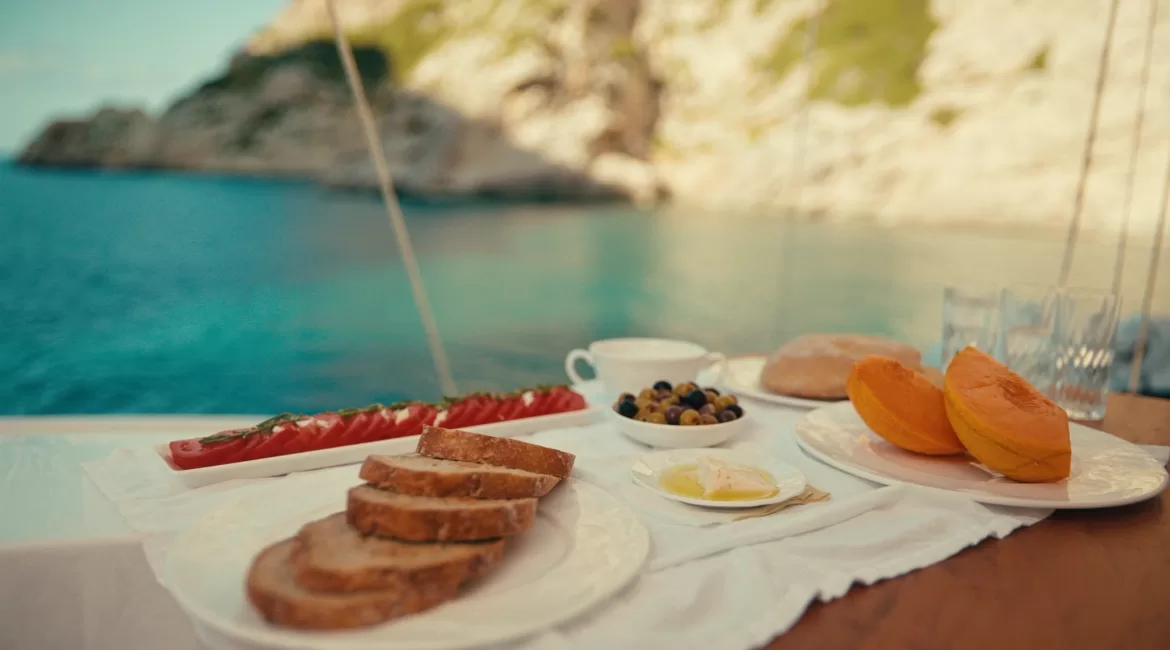 Lunch on board a boat at anchor off Taormina, with bread, tomatoes and melon on deck