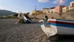 Fishing villages on the Ionian coast of Sicily: wooden fishing boats pulled up on a pebble beach