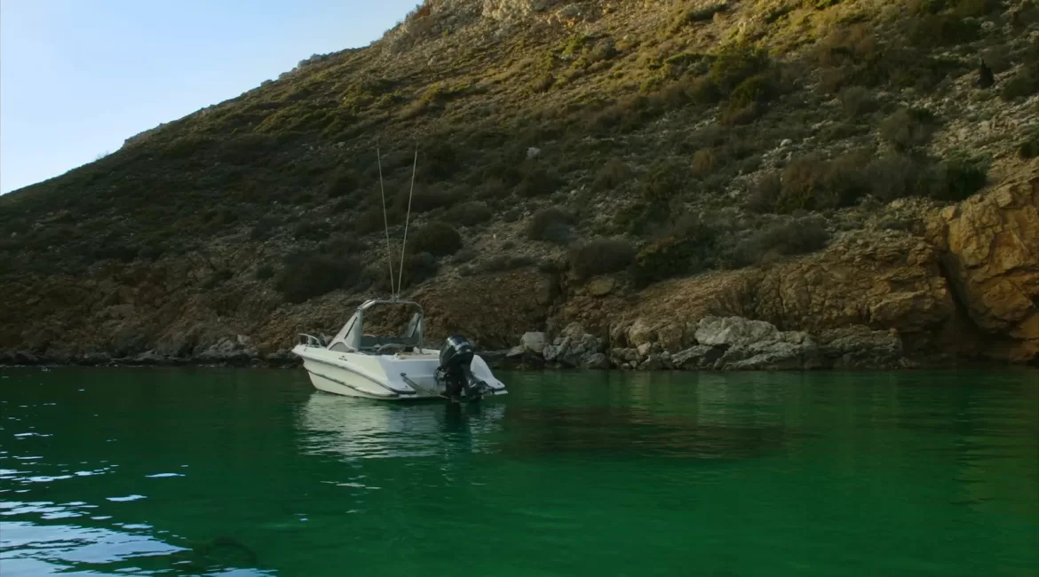 A tailor-made boat day in Taormina: a small white boat at anchor alone in a quiet Sicilian cove