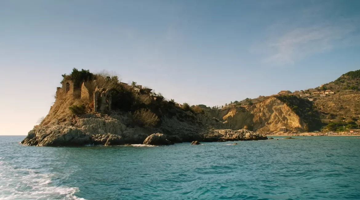 Taormina in September: the coast and Isola Bella seen from calm water in soft early-autumn light
